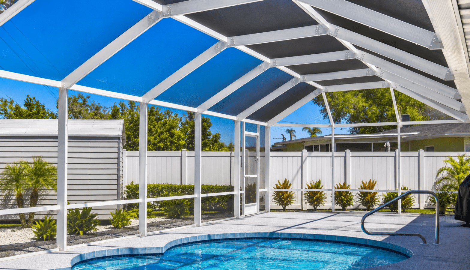 Sunny screened patio with a bright blue swimming pool, white beams, tropical plants, and a modern home exterior creating a relaxing retreat.